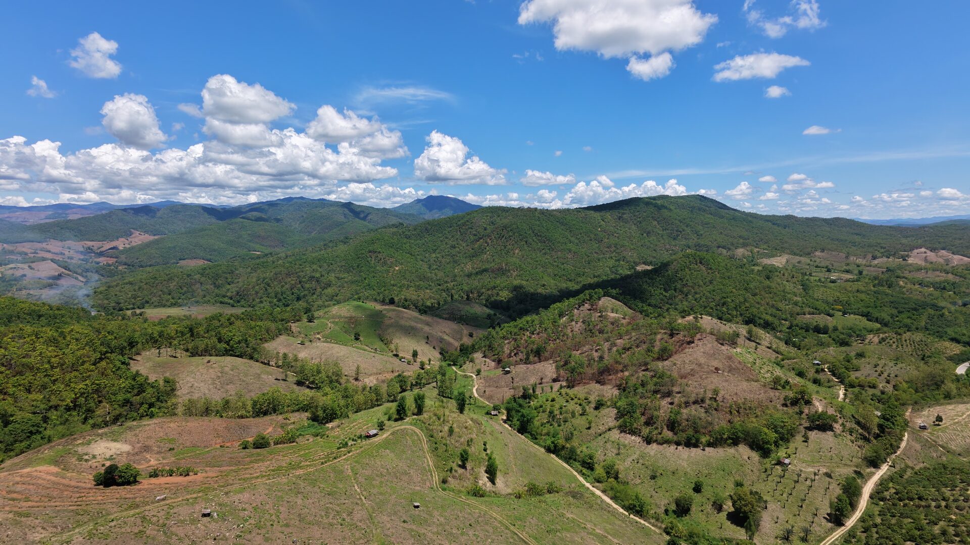 Mae Wang headwaters from a hundred metres up. The patchwork is half the answer — orchards, regrowth, smallholdings. Trail country interleaved with private country. A lot of the day is reading which is which.