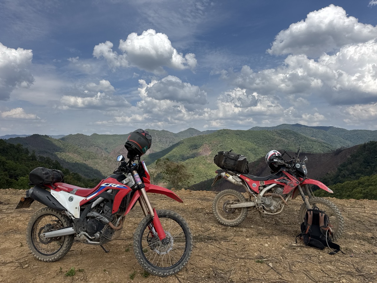 Two CRFs and a panorama somewhere on the Om Koi ridge — the kind of stop you make every twenty minutes on this road.