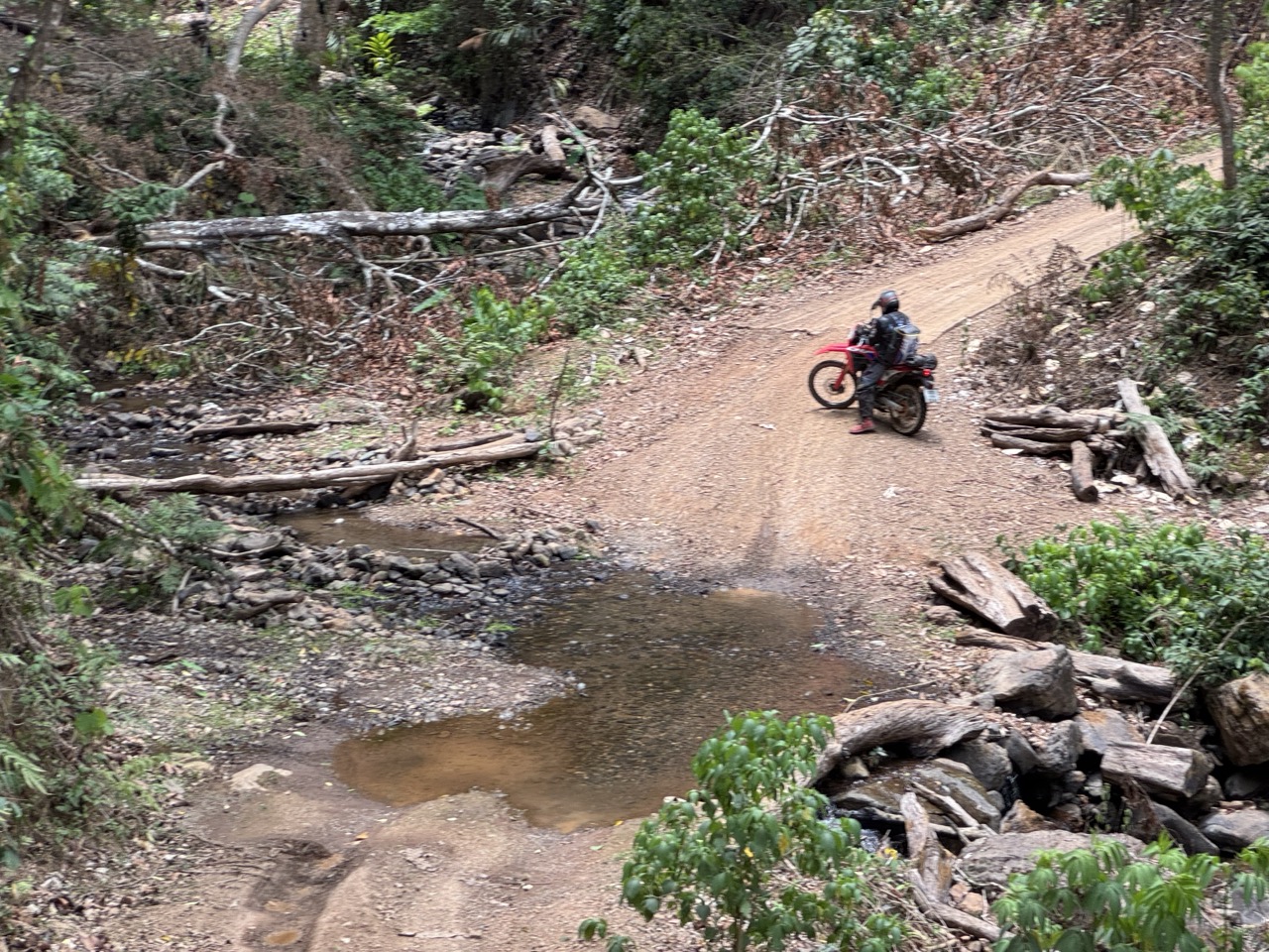 Walking the bike across a stream — small ford, but slick on the rocks.