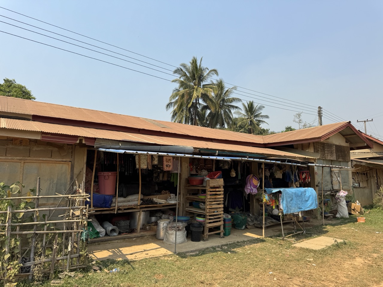 A village shophouse with the standard Lao corrugated roof. Cold drinks inside, snacks if you're lucky, a charging socket if you ask nicely.