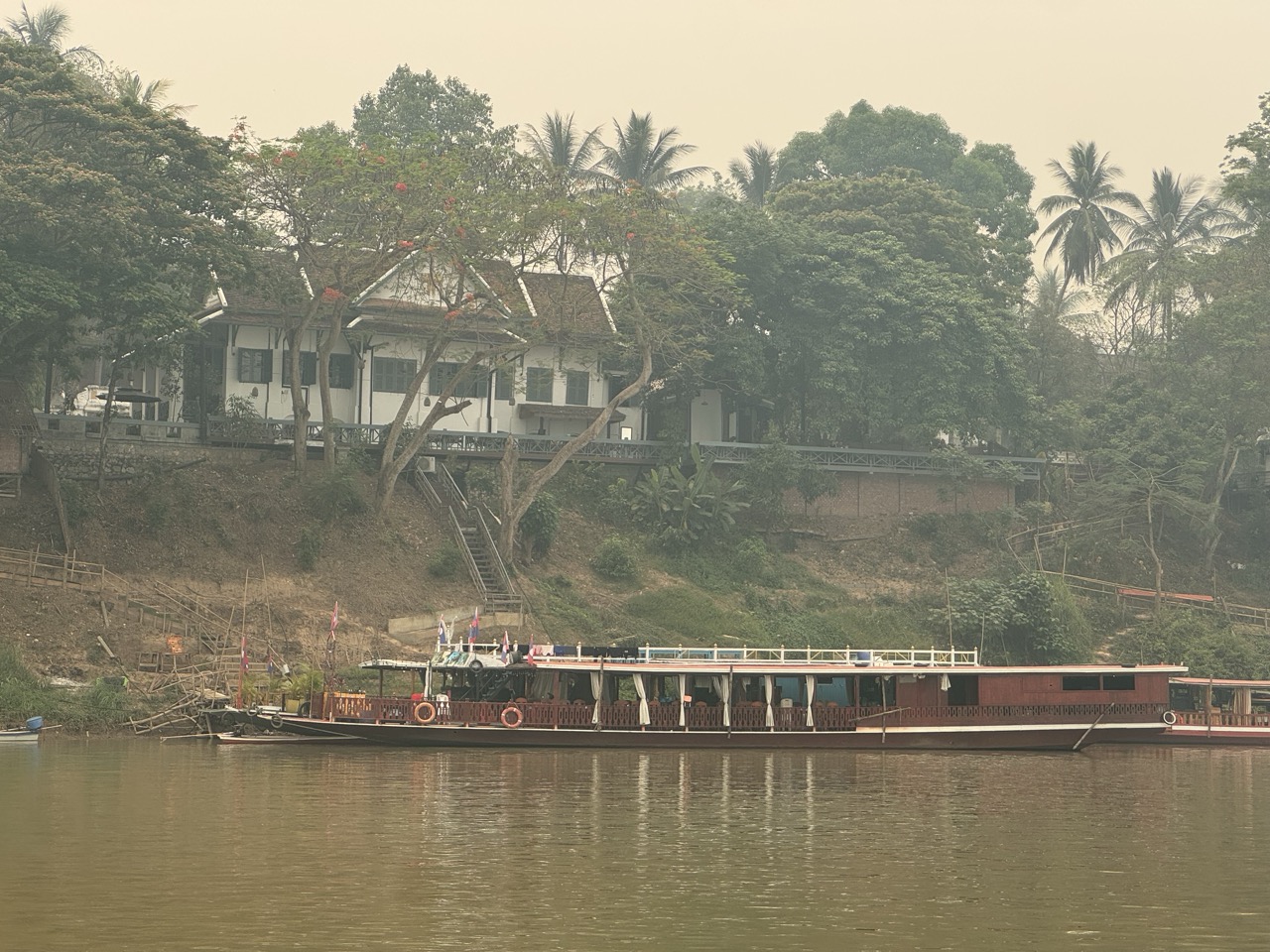 Slow boat moored on the riverbank — the same boats that bring backpackers down from Huay Xai.