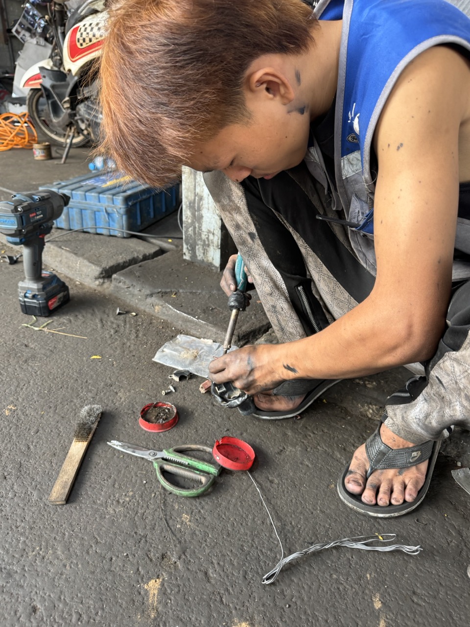 Mechanic crouched over the parts on the ground. He found and fixed the connector inside ten minutes — the welding for the fairing took longer.