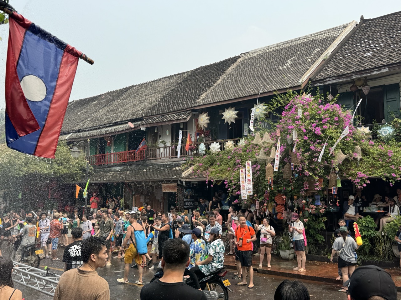 Lao flag flying over the crowd at one of the restaurants on the main street.