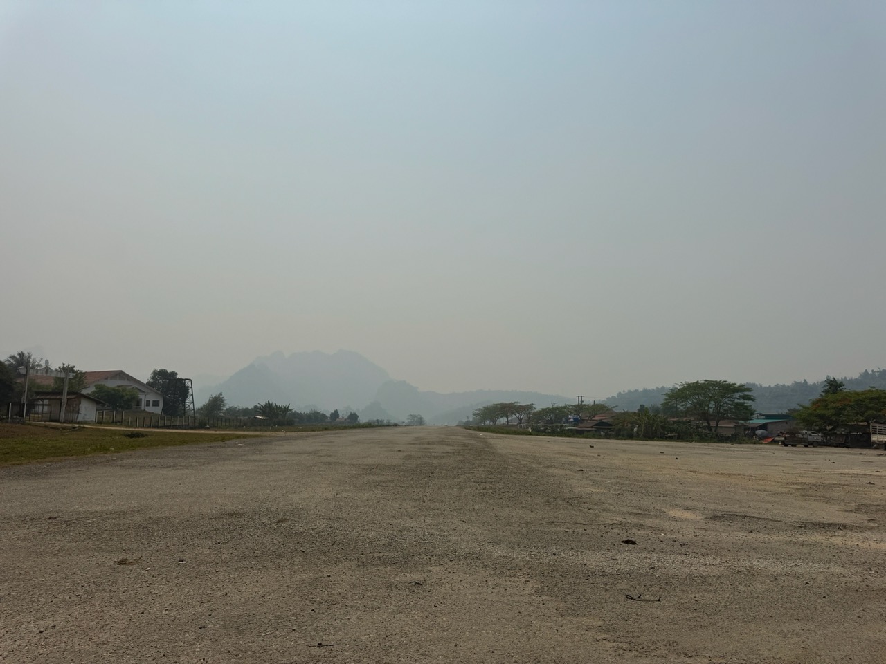 A former Lima Site — one of the CIA's covert airstrips from the Secret War era. Now a gravel expanse in the middle of nowhere. There are dozens of these scattered across the Hmong highlands.