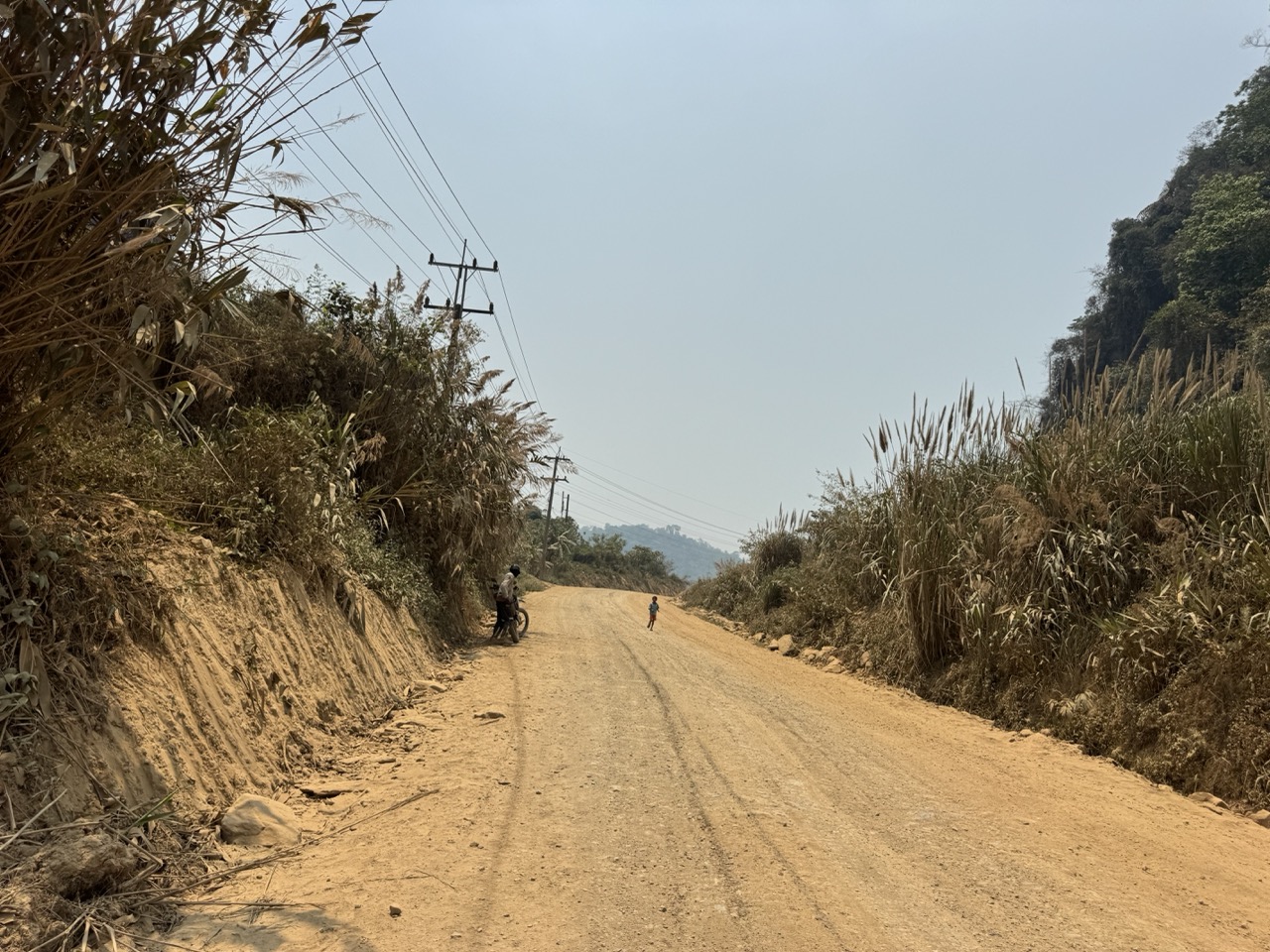A Lao child on an empty dirt road. He stared us down all the way through the village.