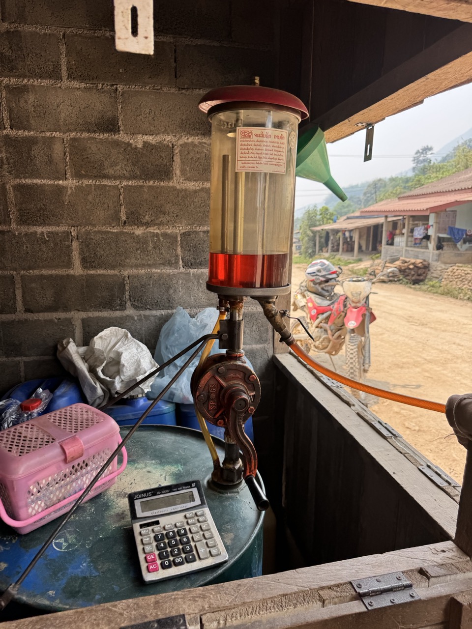 Roadside hand-pump fuel dispenser. We topped up here — there were no other obvious fuel options for hours after this.