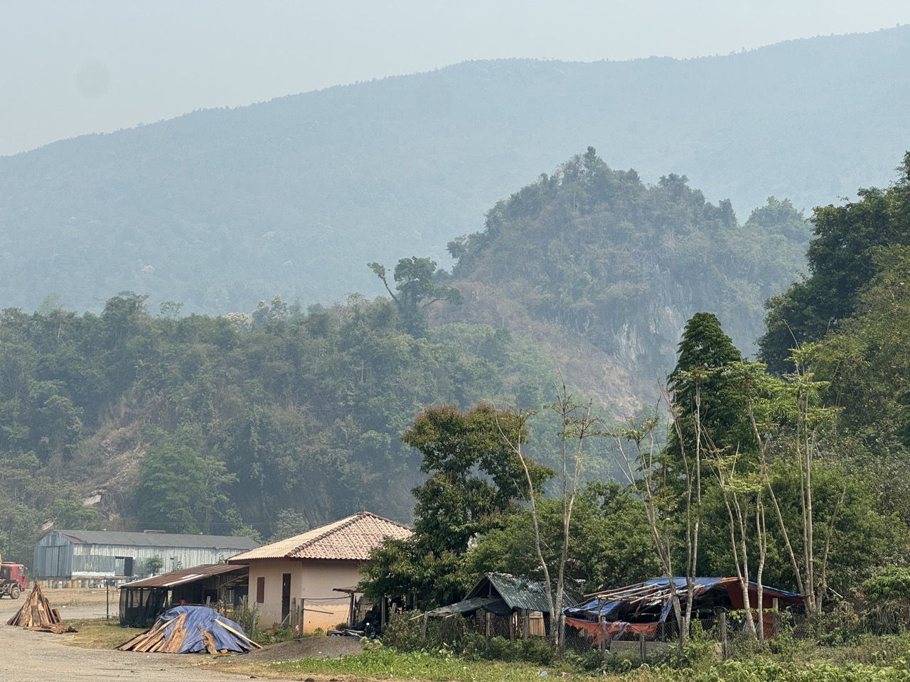 A village with a sawmill and the first proper karst peaks behind it. Vang Vieng is getting close.