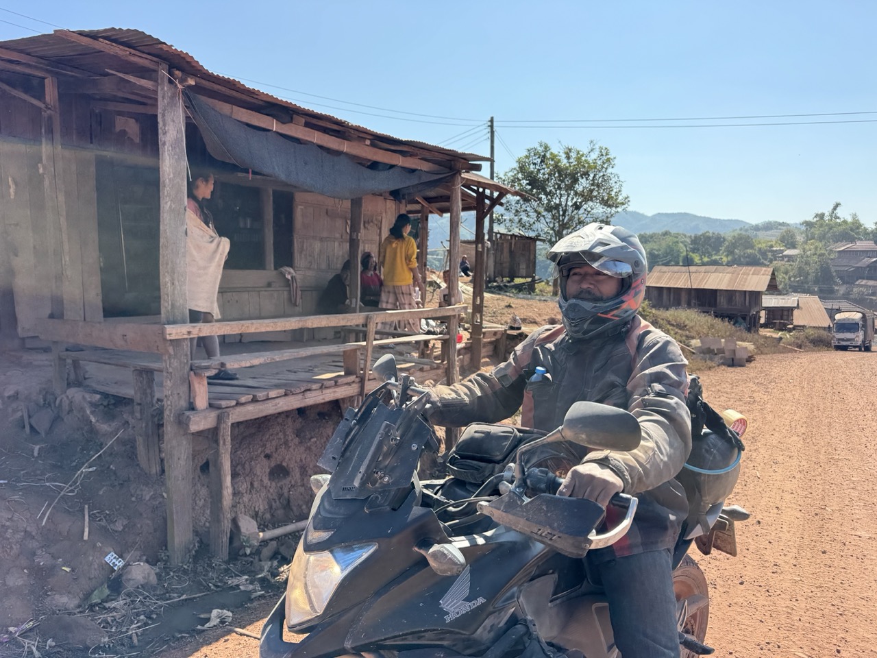 One of the smaller villages on the road to Phongsali — wooden houses, corrugated roofs, banana trees in the yard.