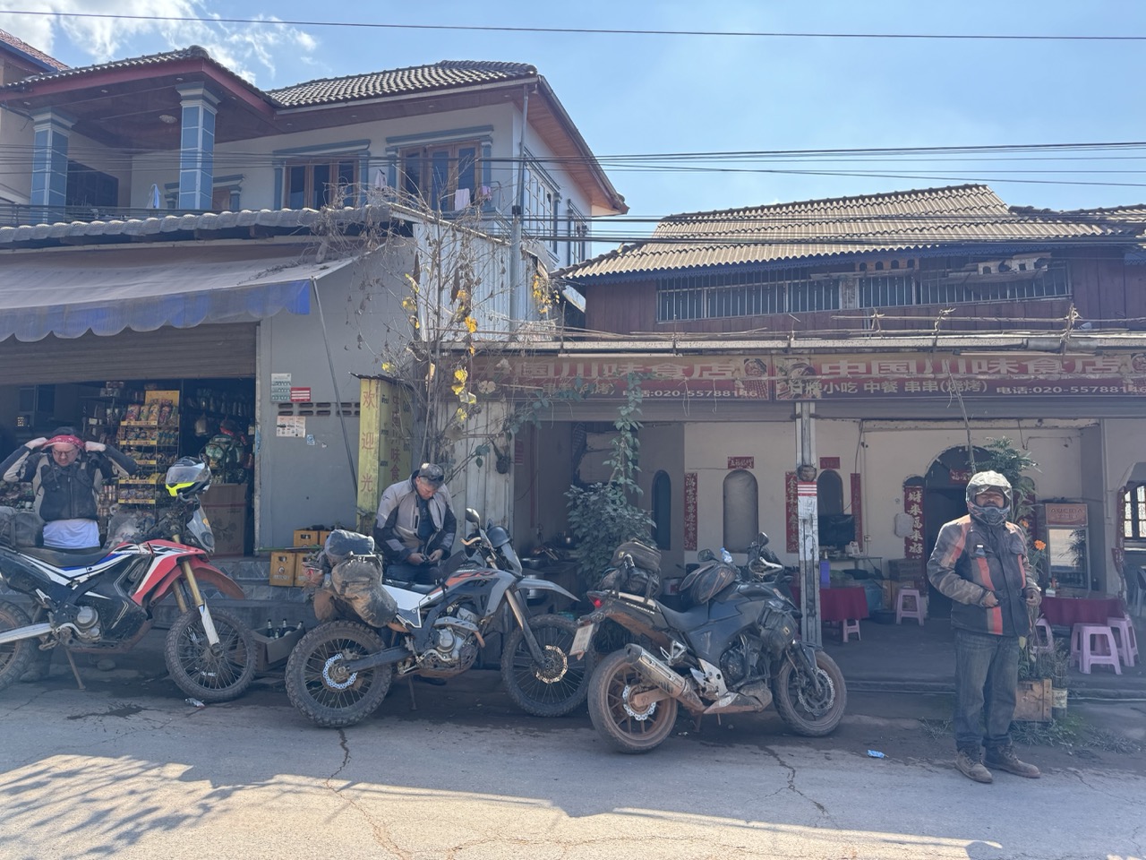 Mid-climb lunch stop. Chinese cuisine, Chinese signage, Chinese phone number — the default in this corner of Laos.