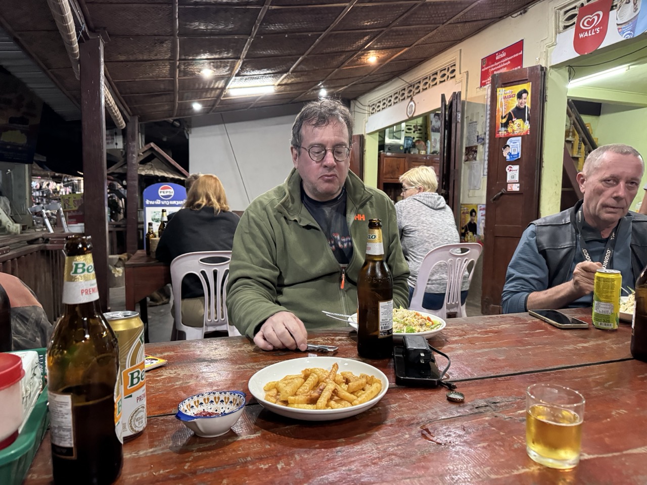 Dinner in Muang Khua — Beerlao, fried snacks, and the relief of being off the bikes after the longest day yet.