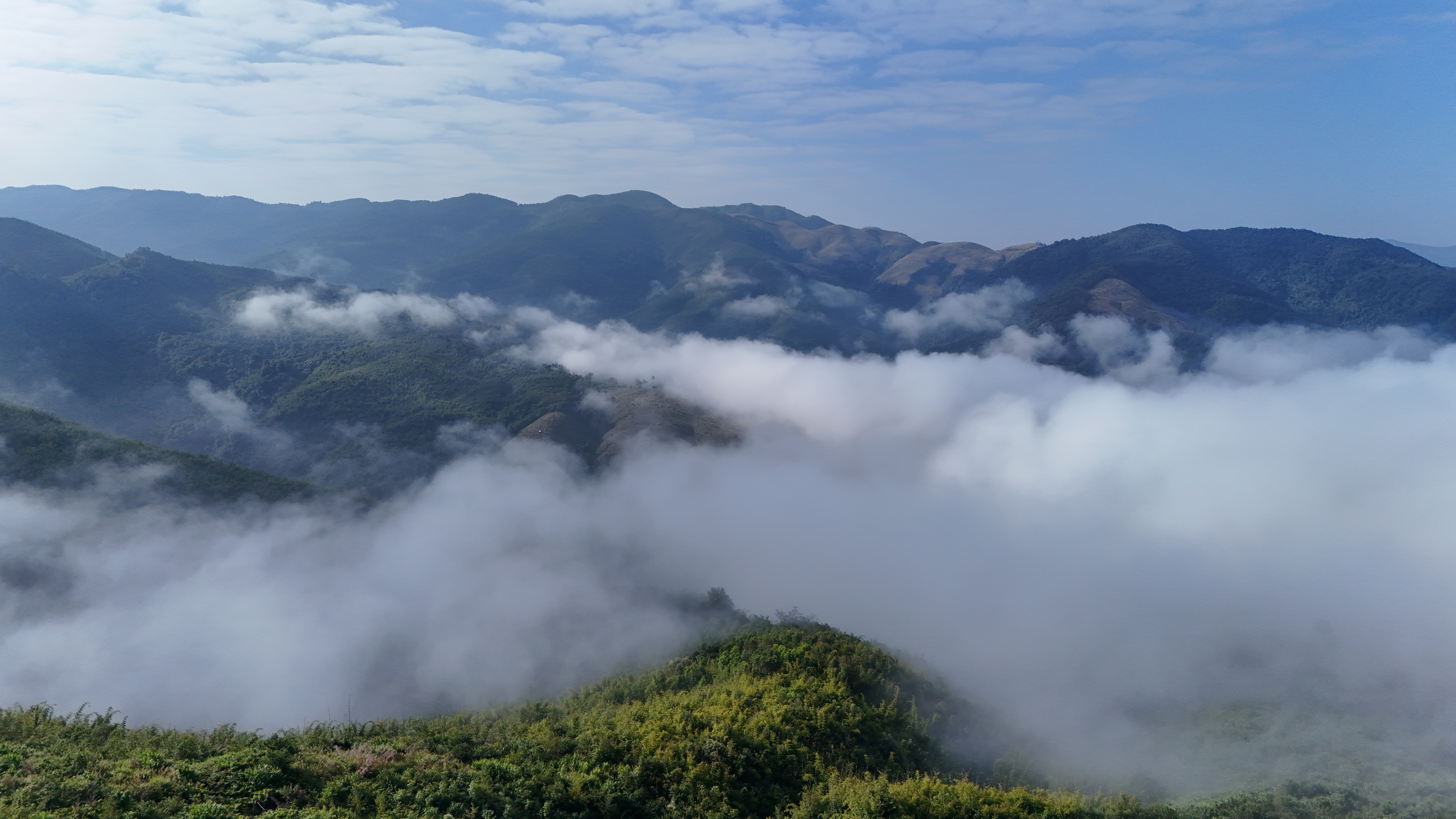 Sea of clouds in the valleys leaving Muang Khua — the kind of morning that justifies the early alarm.