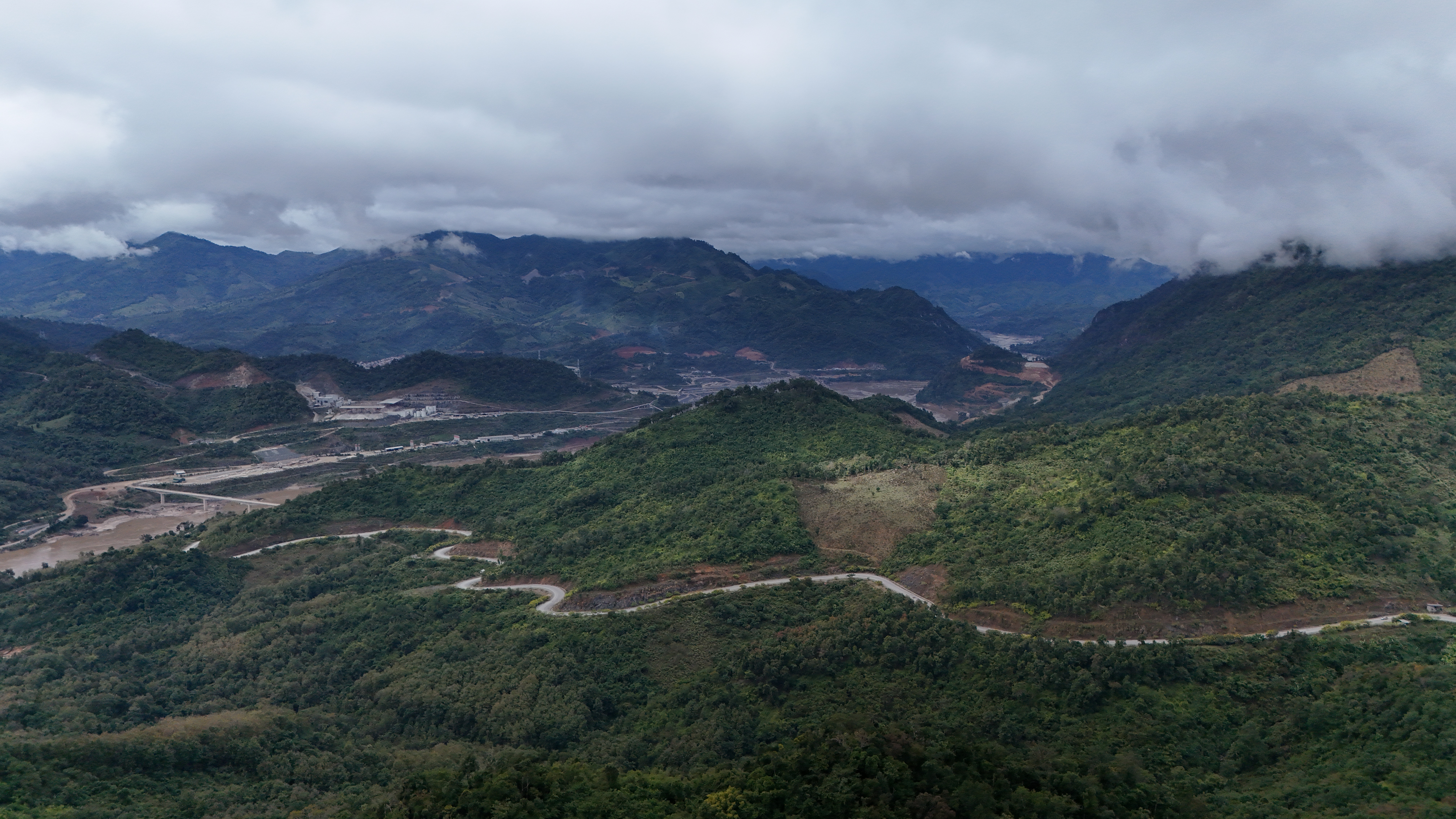 The Mekong upstream of Luang Prabang — milk-tea brown water, jungle to the waterline, the only road in is the river.